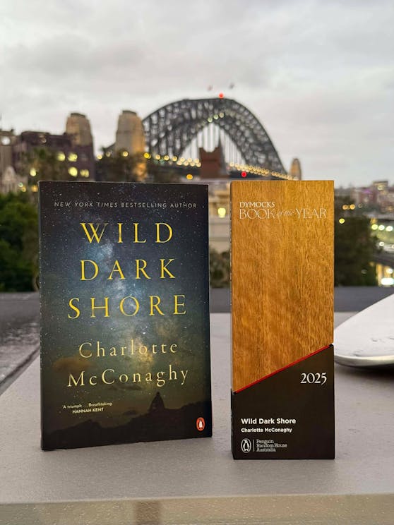 Wild Dark Shore next to the Dymocks Book of the Year 2025 trophy.