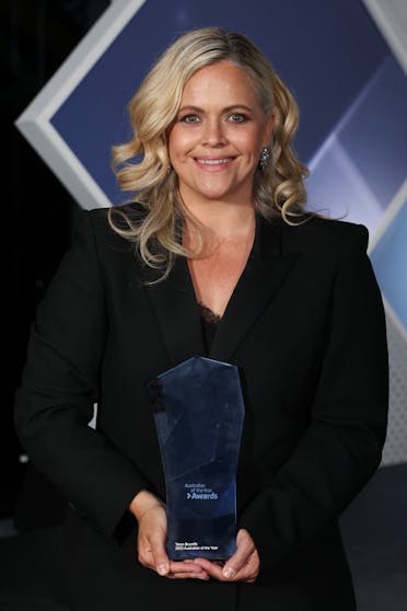 Taryn Brumfitt holding a glass trophy at the Australian of the Year awards ceremony.