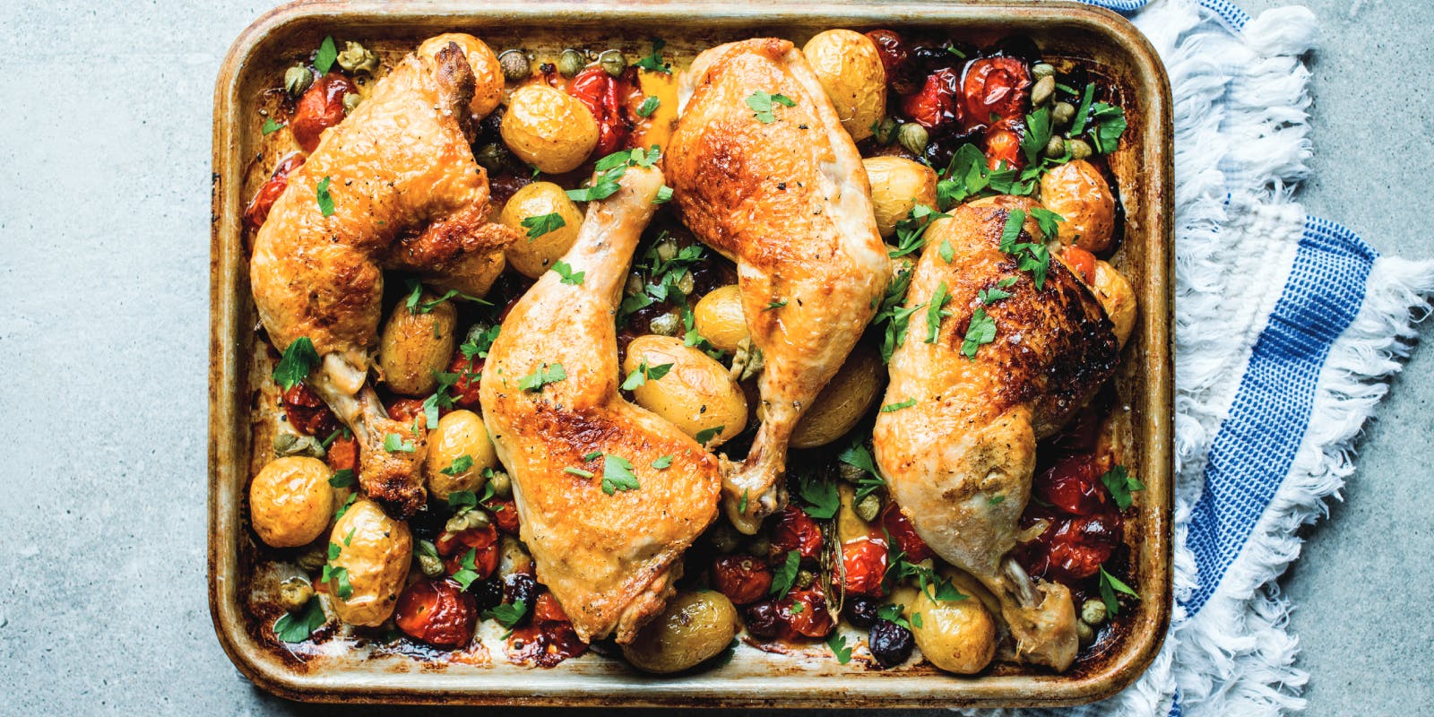 Chicken traybake with baby potatoes, olives, capers and cherry tomatoes