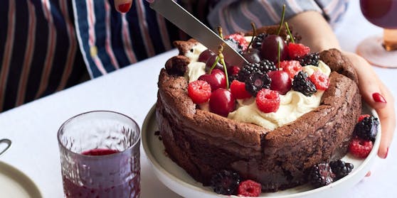 Photo of collapsing chocolate cake with berries on top. 