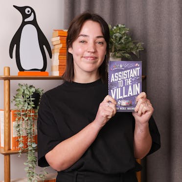 Lucy holding Assistant to the Villain by Hannah Nicole Maehrer.