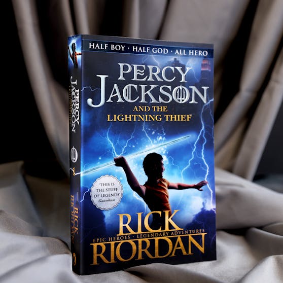 Percy Jackson book 1 against a cloth background. 