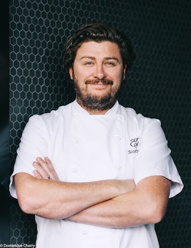Chef Scott Pickett with his arms crossed, wearing a chef's shirt. 